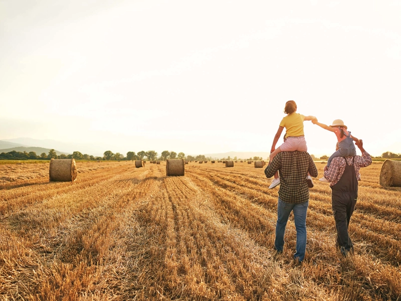 Family walking in a hay field.