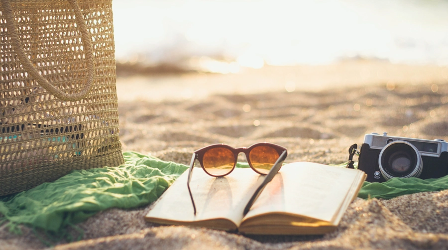 Sunglasses on a book on the beach.