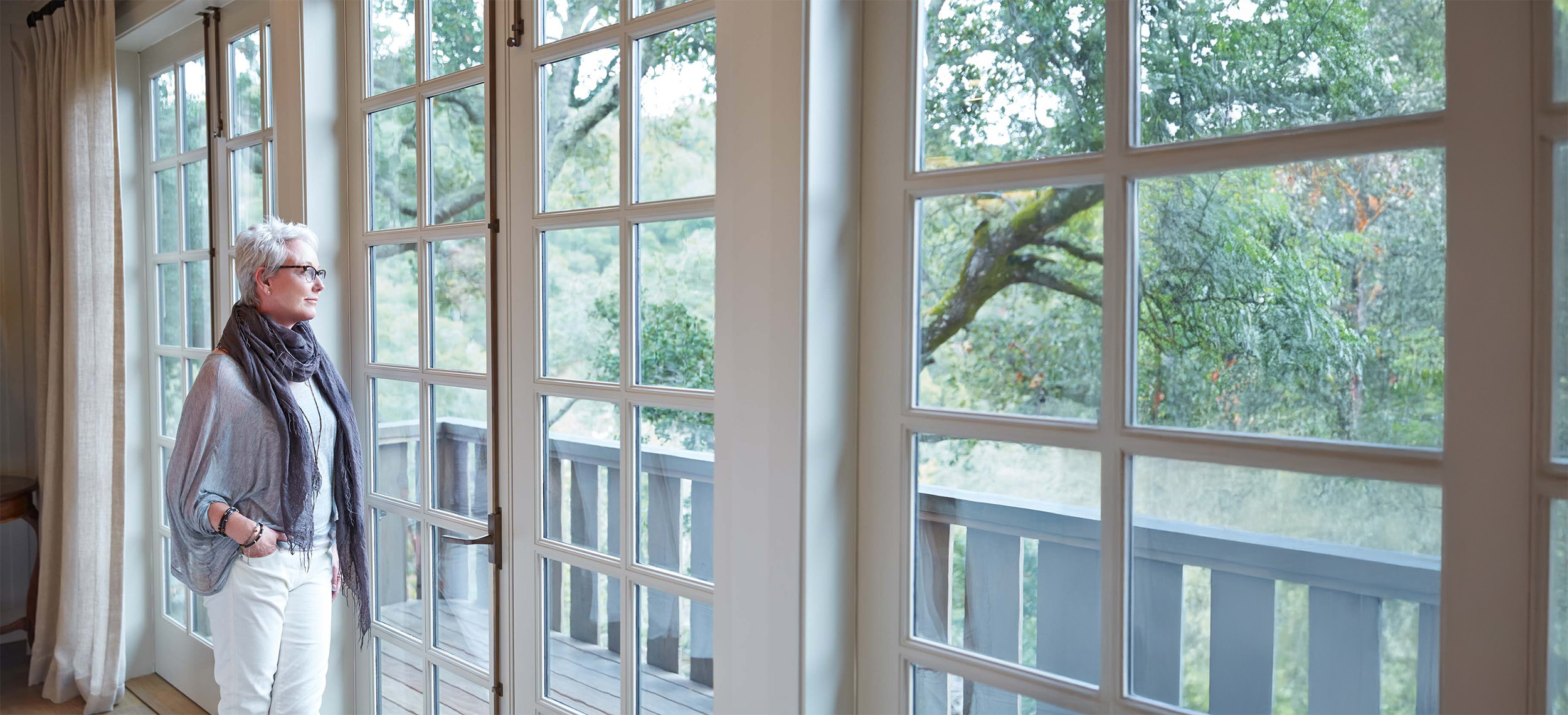 Woman looking out her windows.