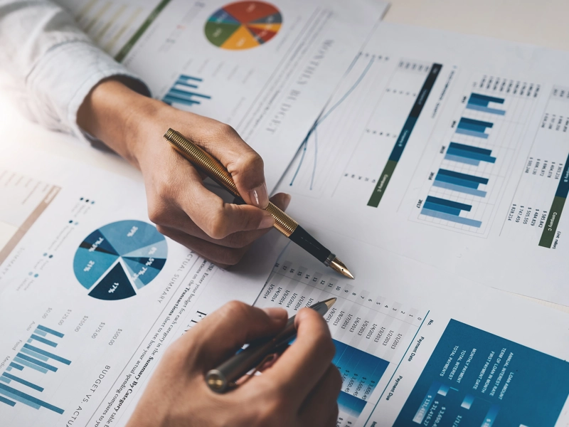 Two people reviewing charts and graphs.